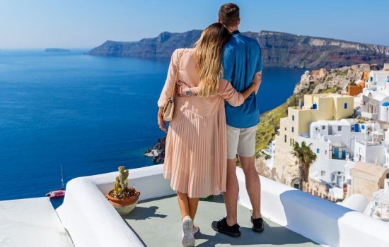 couple on honeymoon overlooking santorini